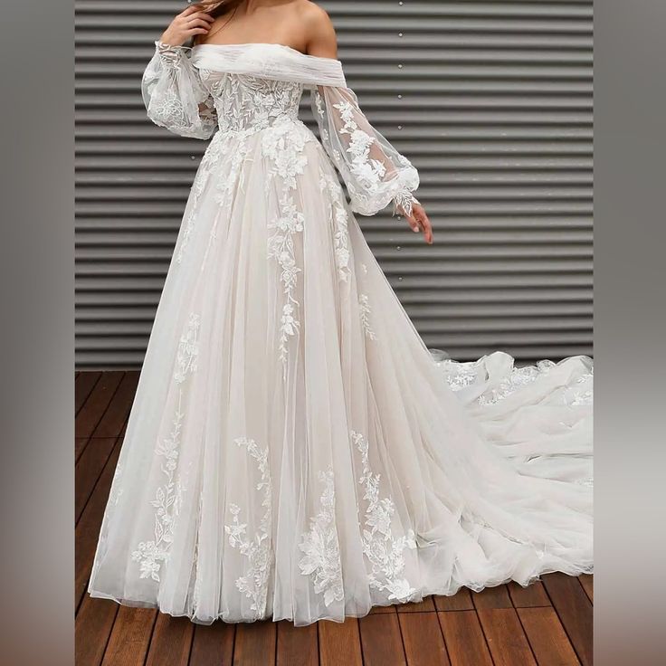 a woman in a white wedding dress standing on a wooden floor with her arms behind her back