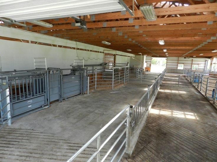 the inside of a building that has several stalls with bars on each side and metal railings