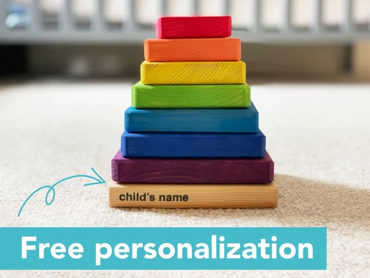 a stack of colorful wooden blocks sitting on top of a white carpet with the words child's name and free personalization