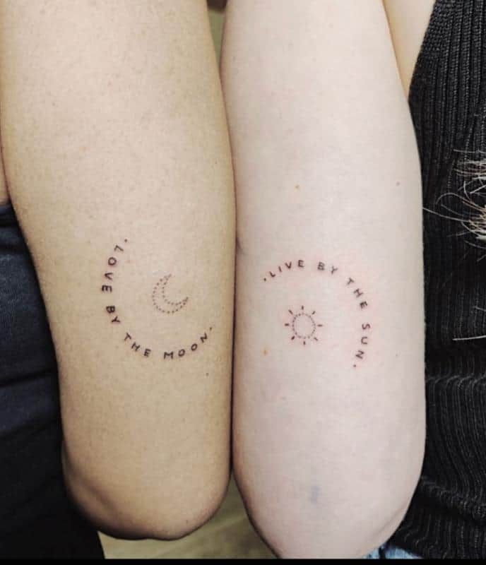 two people with matching tattoos on their arms that say live by the sun and love by the moon