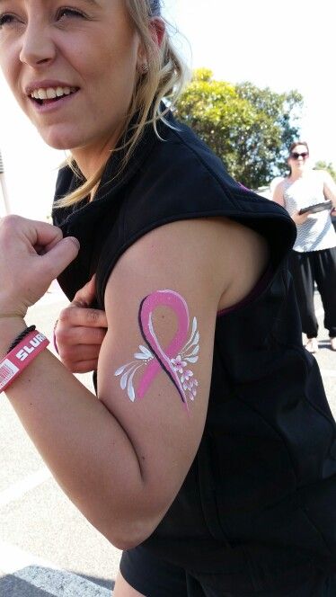 a woman with pink ribbon on her arm