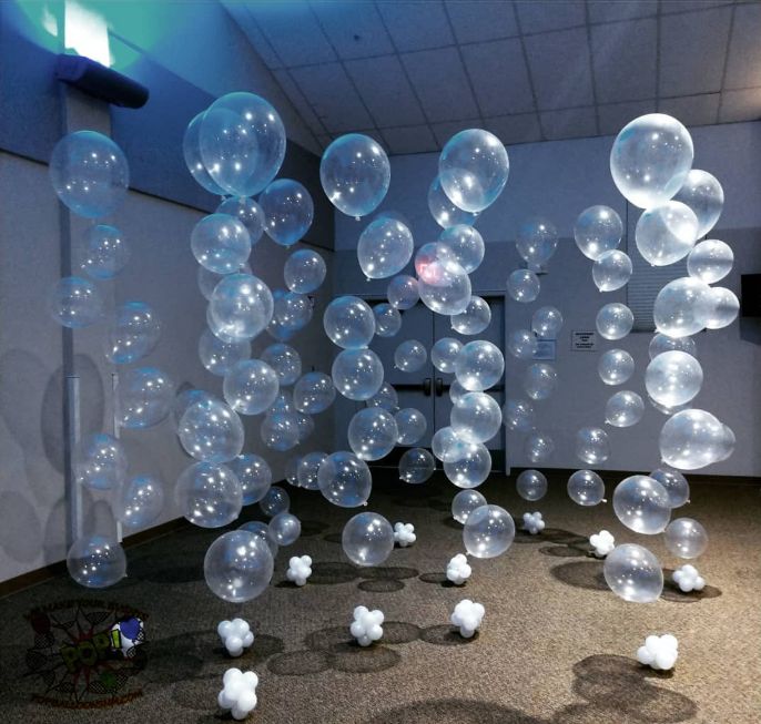 balloons are floating in the air inside an empty room with carpet and ceiling lights on either side