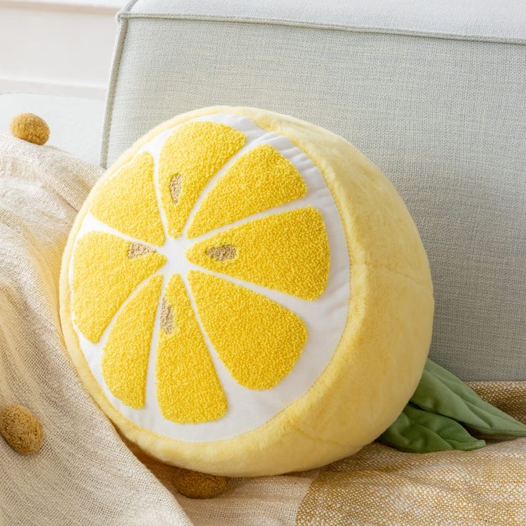 a lemon shaped pillow sitting on top of a couch