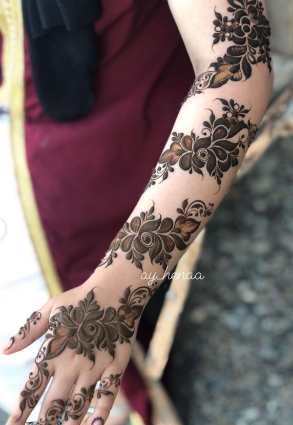 a woman's hand with henna tattoos on it