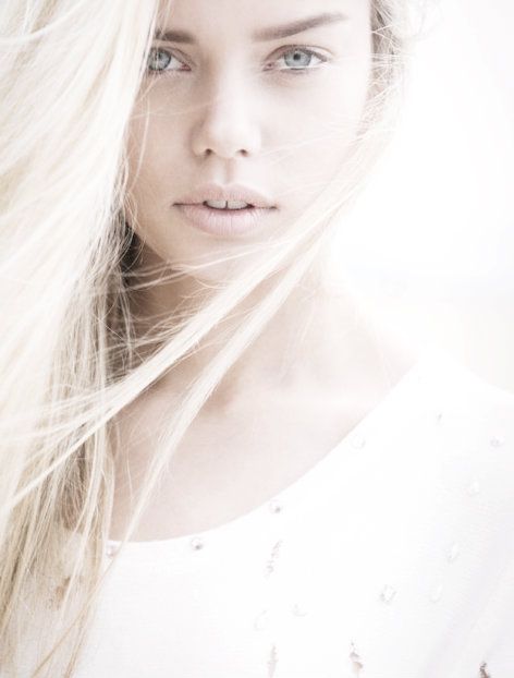 a woman with long blonde hair is posing for the camera and looking at the camera