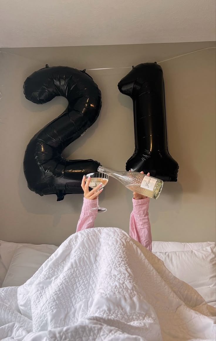 a person laying in bed with an air filled number balloon