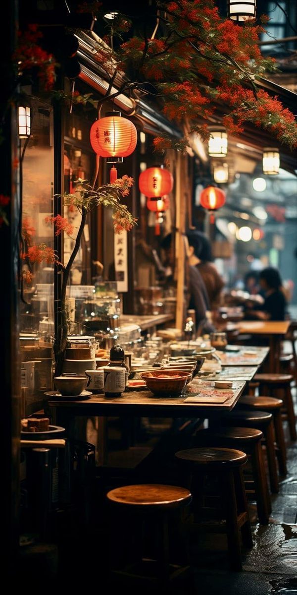 an outdoor restaurant with tables and stools in the rain, lanterns hanging from the ceiling