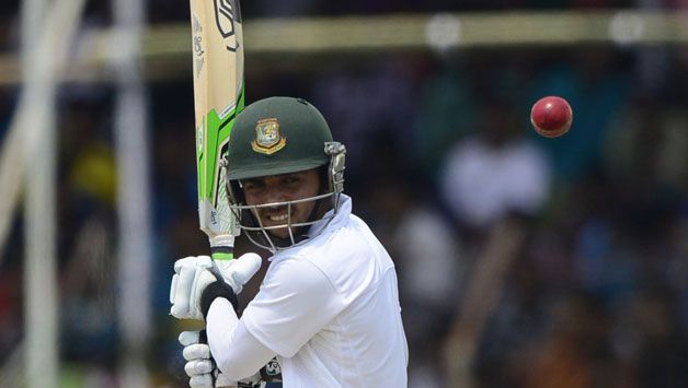 a man swinging a cricket bat at a ball