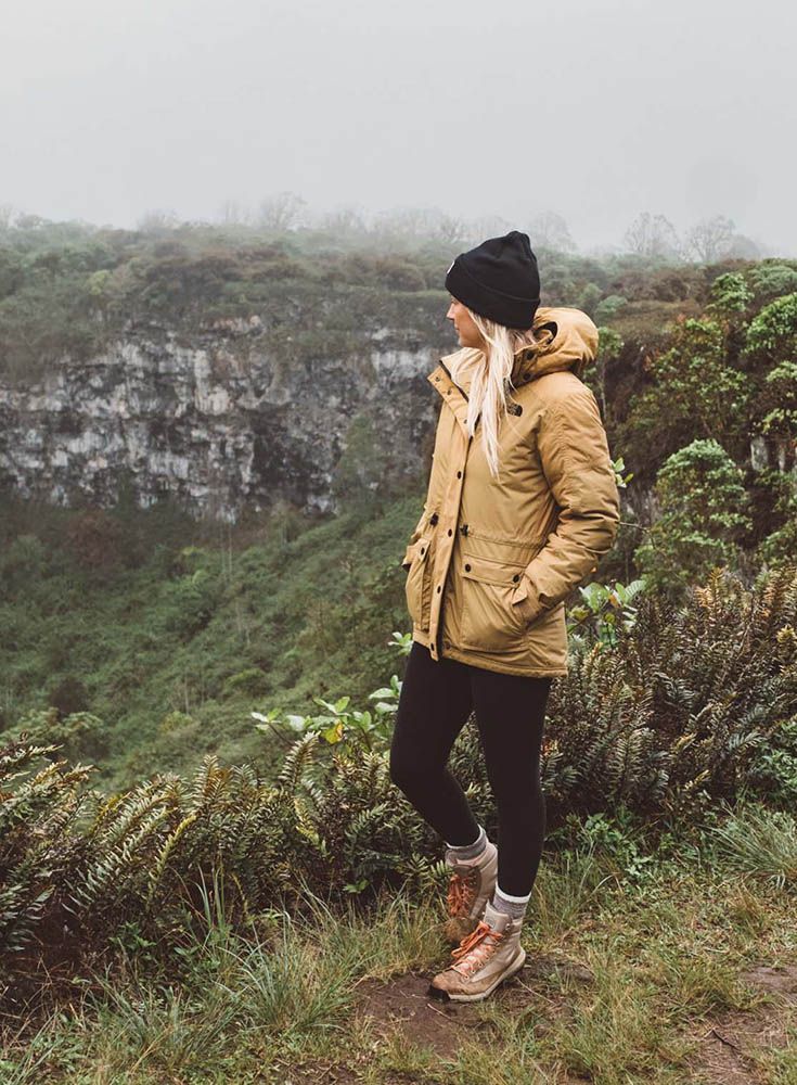 a woman standing on the edge of a cliff