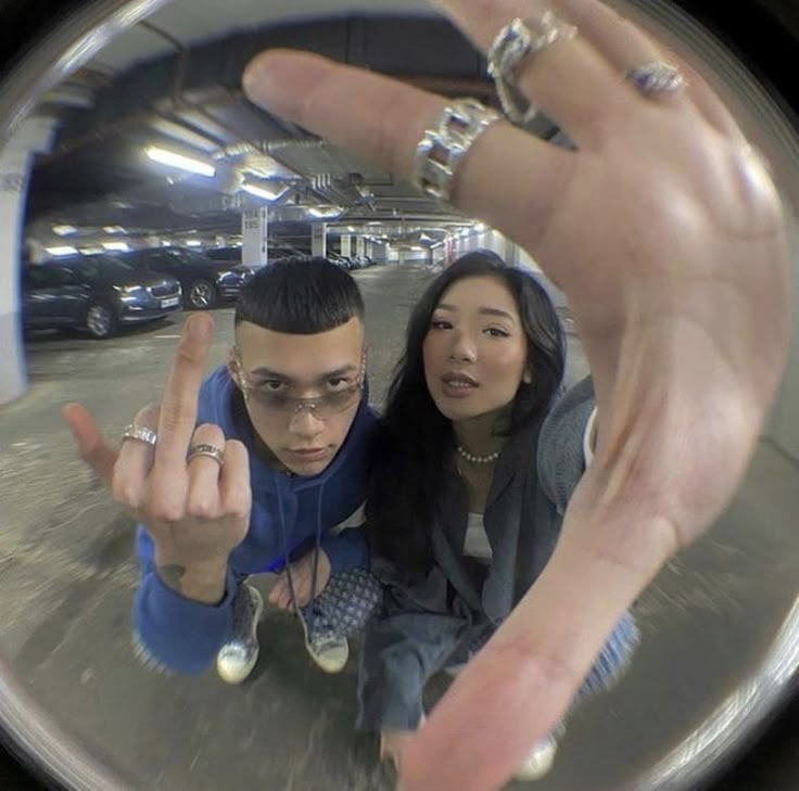 a man and woman taking a selfie in front of a mirror with their fingers up