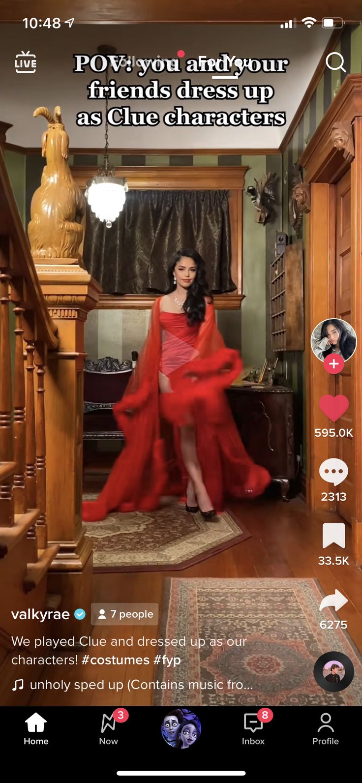 a woman in a red dress sitting on top of a wooden floor next to stairs