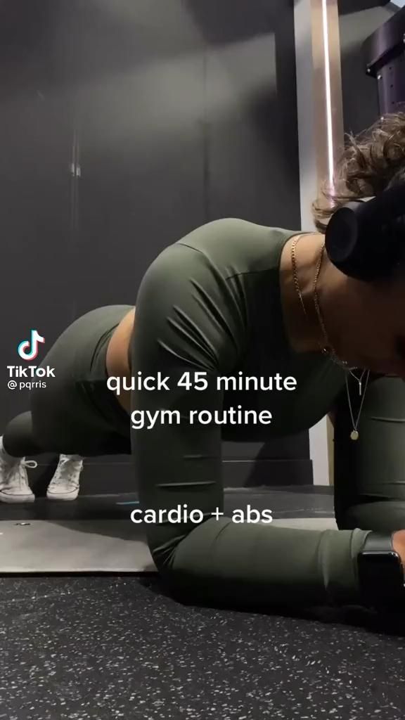 a woman is doing push ups on the floor with her headphones in her ears