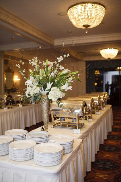 a buffet table with plates and flowers on it