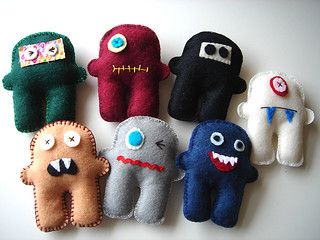 six handmade monster finger puppets on a white surface