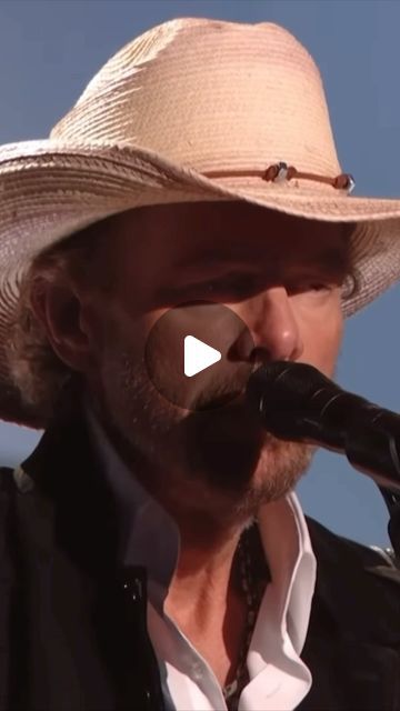 a man in a cowboy hat singing into a microphone