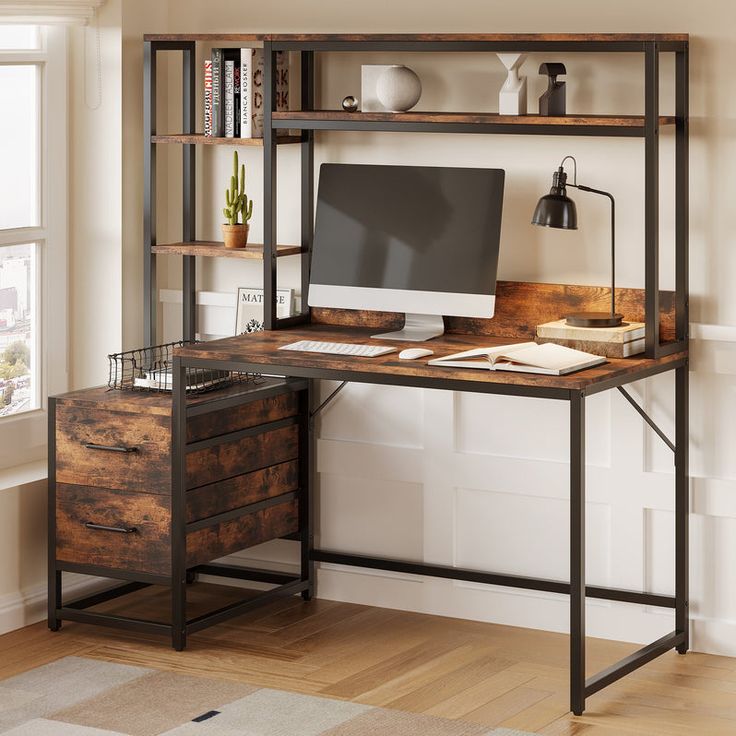 a desk with a computer on top of it in front of a bookshelf