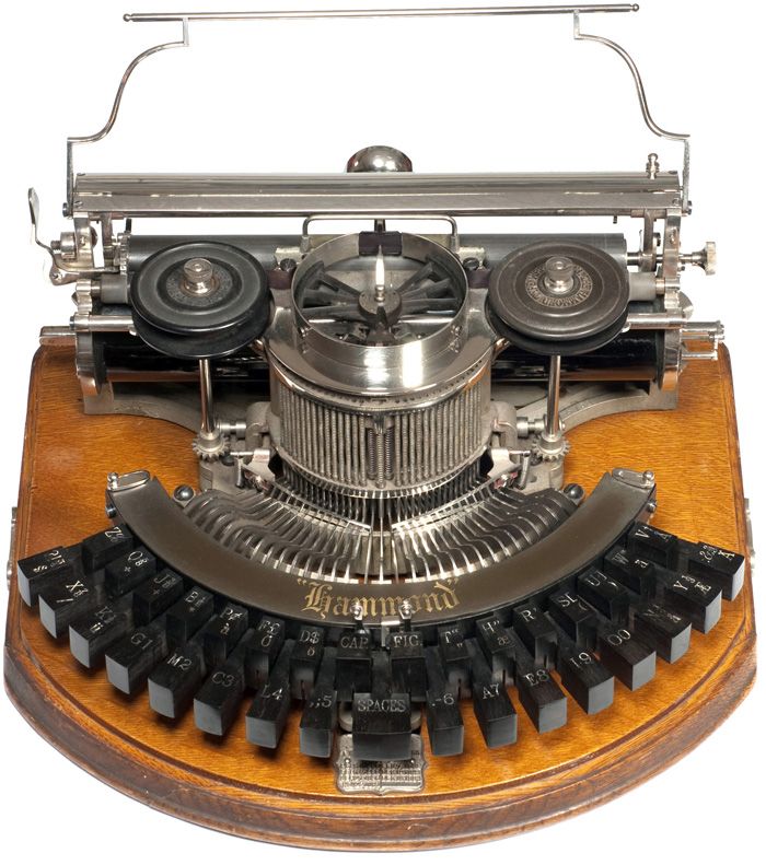 an old fashioned typewriter sitting on top of a wooden table next to a white background