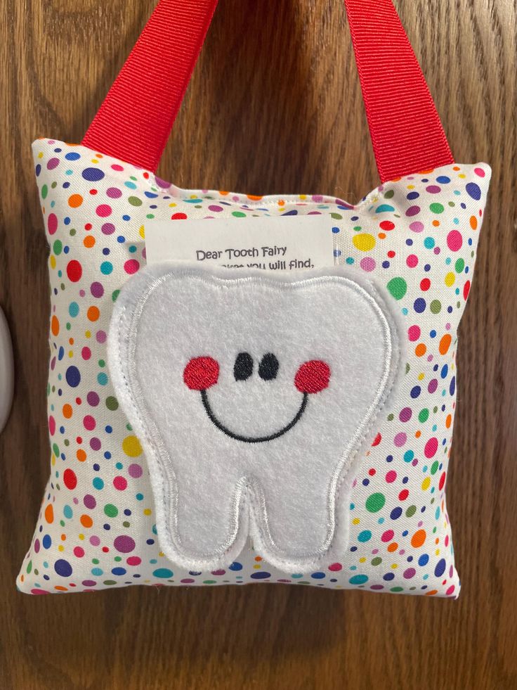 a tooth shaped pillow hanging on a wall