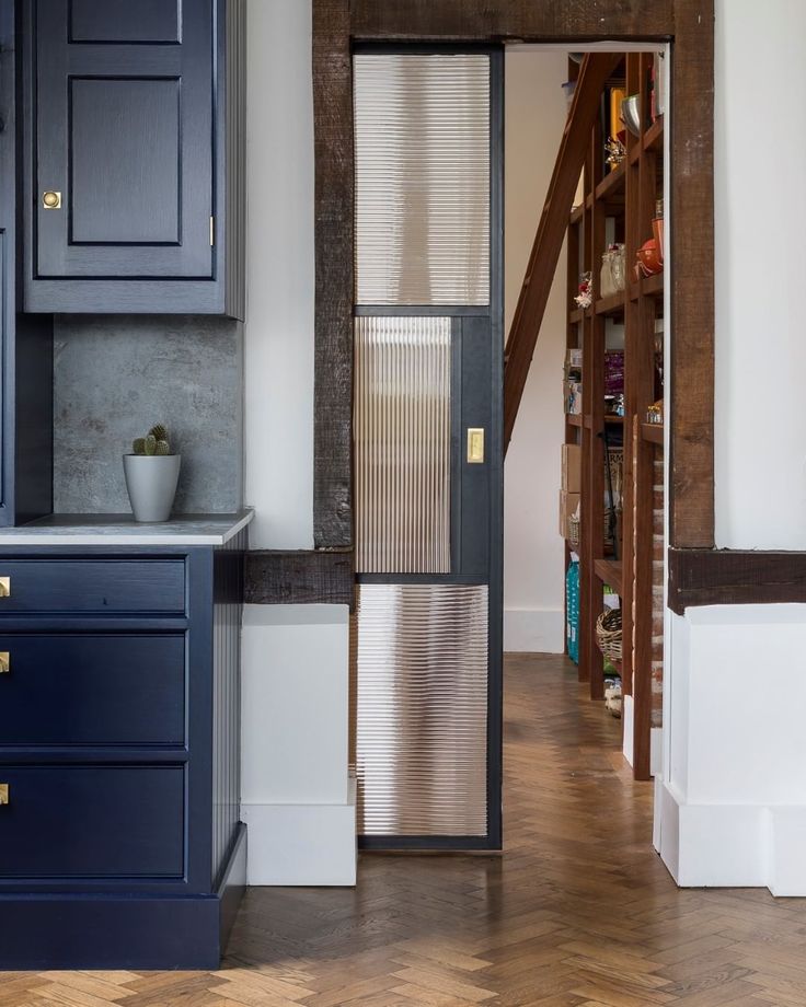 an open door leading into a kitchen with blue cabinets