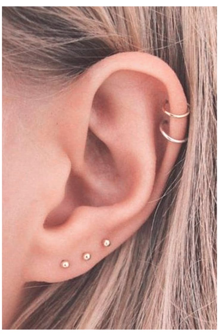 an ear with two piercings on top of it