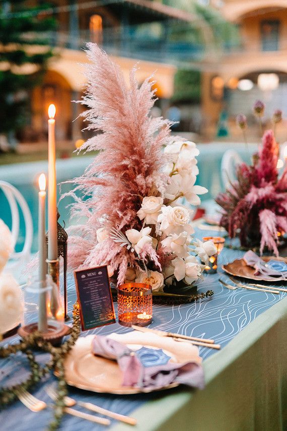 the table is set with flowers, candles and place settings for an elegant dinner party