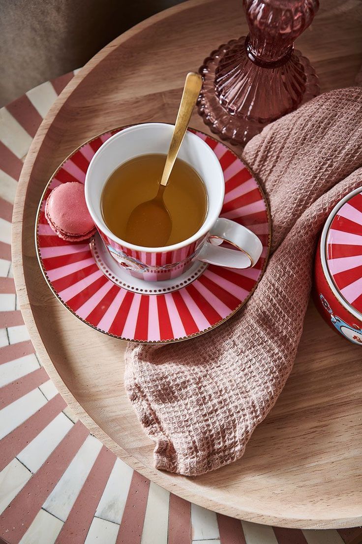 a cup of tea and some cookies on a plate with a cloth next to it