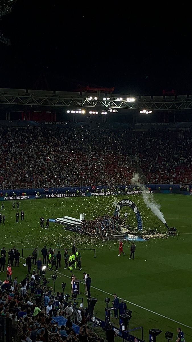 a stadium filled with lots of people and confetti being thrown on to the field