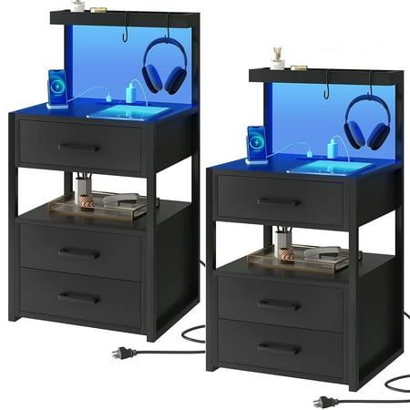 two black nightstands with headphones on each side and blue light in the middle