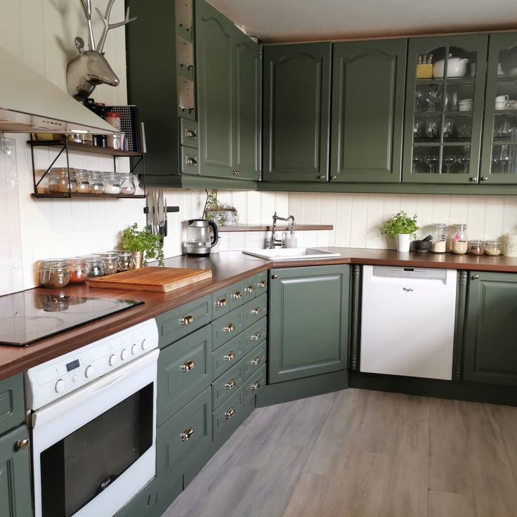 a kitchen with green cabinets and white appliances