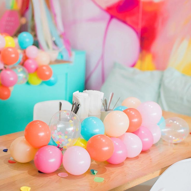 balloons and confetti on a table at a birthday party