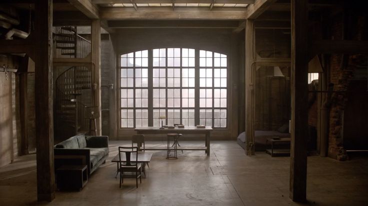 an empty room with lots of windows and furniture in the center, along with tables and chairs