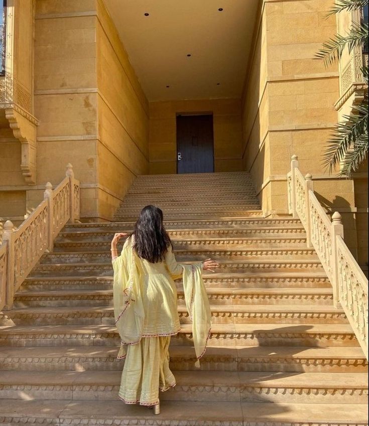 a woman walking up some steps in front of a building