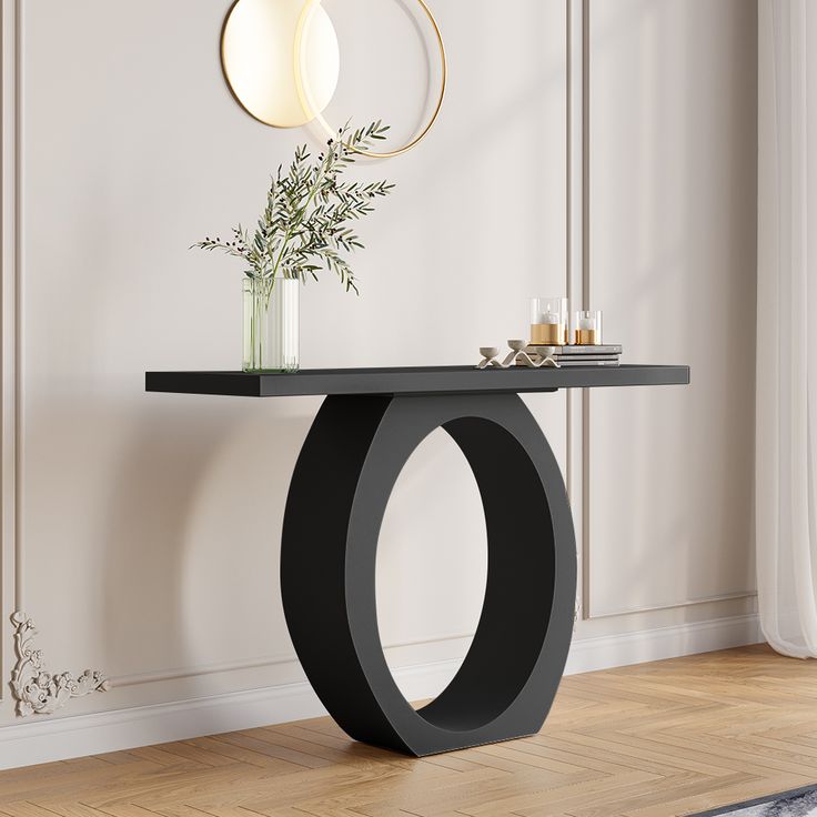 a modern console table with a vase and candle holder on the top, in front of a white wall