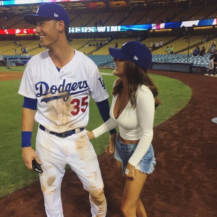 a baseball player and a woman walking on the field