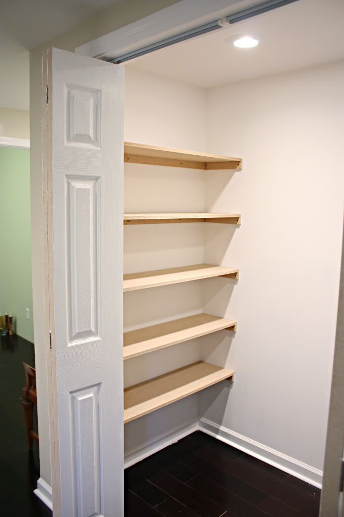 an empty closet with shelves and doors open to reveal another room in the house,