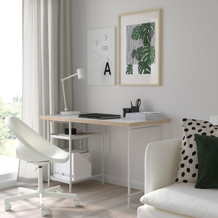 a white chair sitting in front of a desk with a computer on top of it