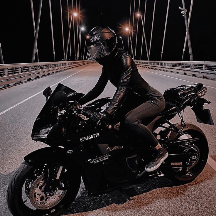 a person on a motorcycle in the middle of a road at night with lights on