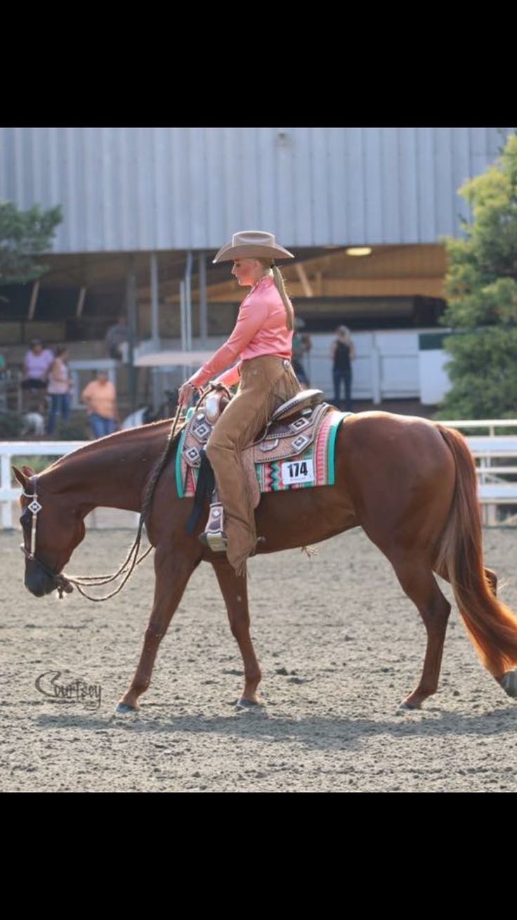 a woman riding on the back of a brown horse