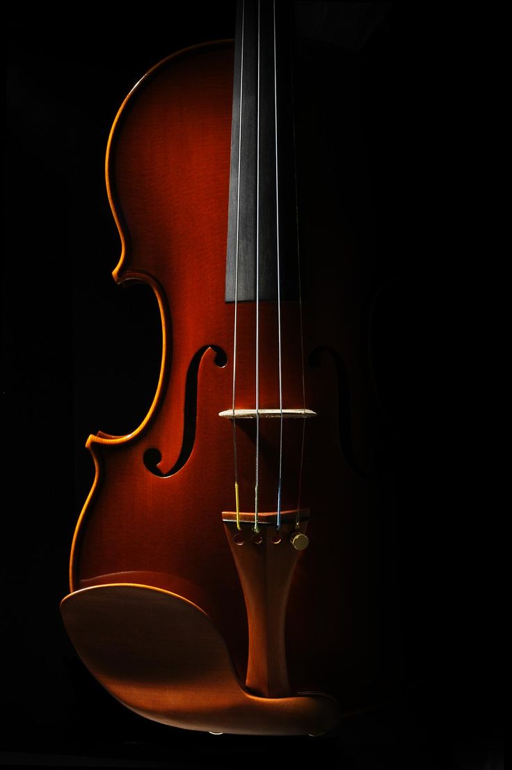 a violin is shown in the dark with its strings still attached to it's back