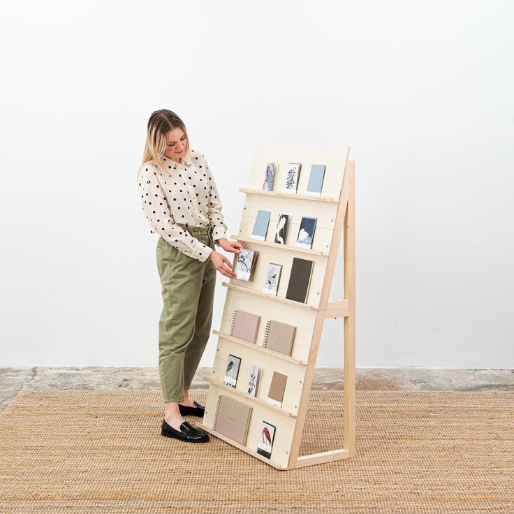 a woman standing next to an easel with pictures on the front and back sides