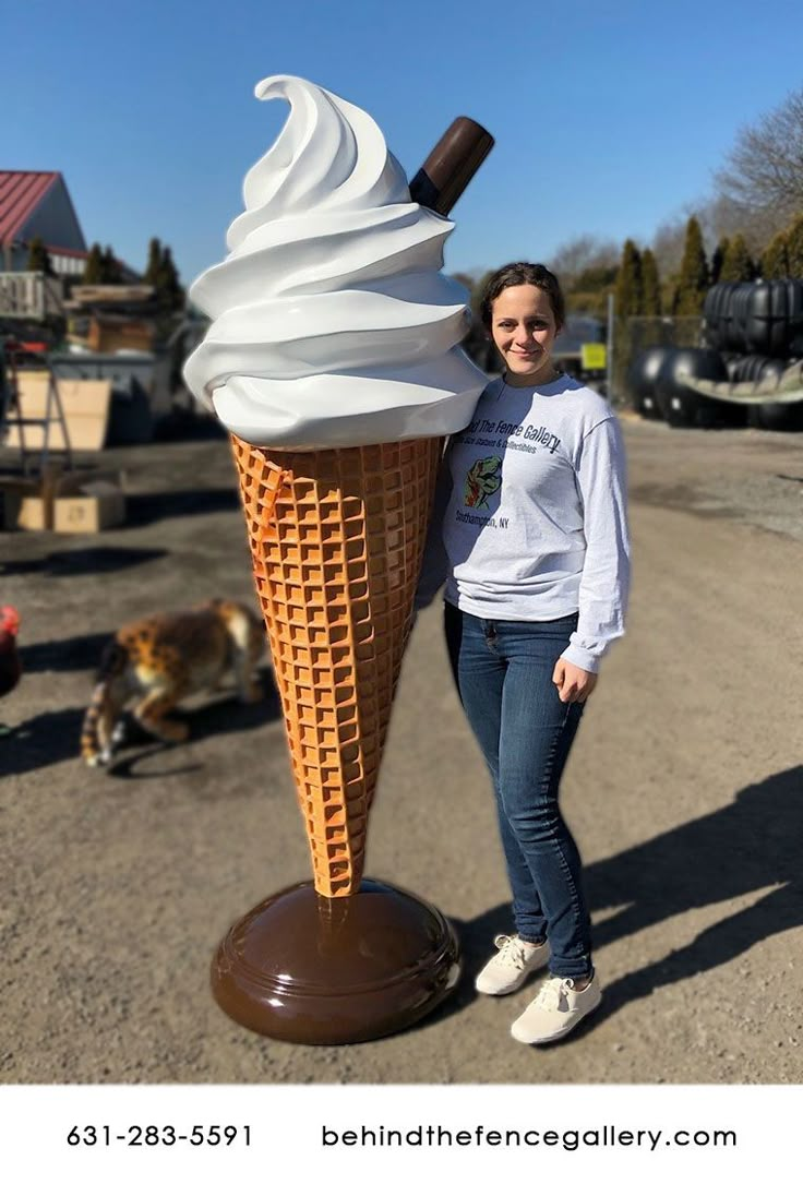 a woman standing next to an ice cream cone