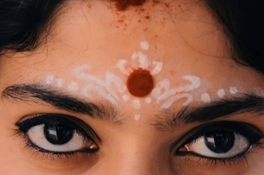 a close up of a person's face with white paint on their forehead and eyes