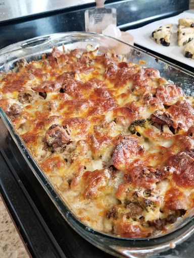 a casserole dish with meat and cheese in it sitting on a stove top