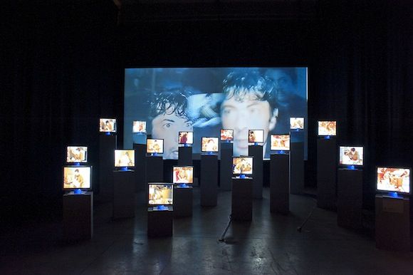 an art installation with multiple video screens on the wall