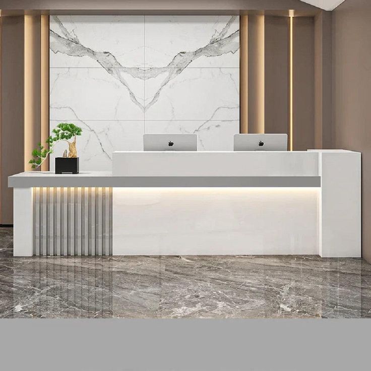 an office with marble floors and walls, along with a white reception desk that has two laptops on it