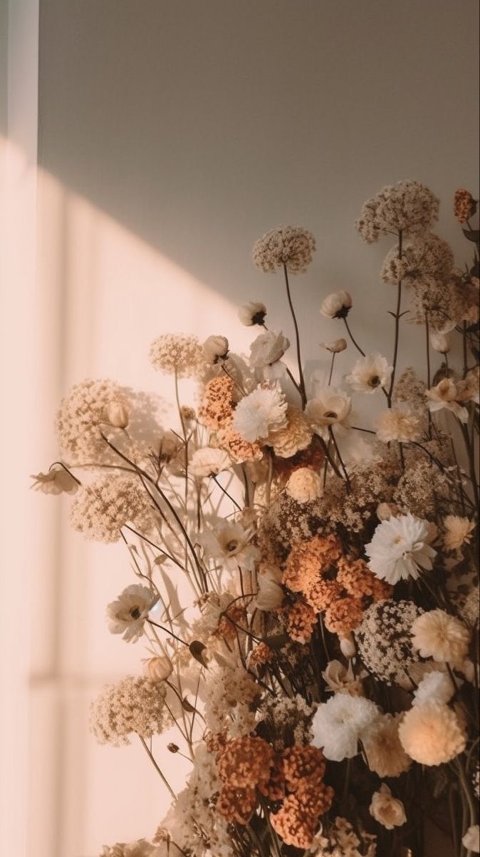 a vase filled with lots of white and orange flowers