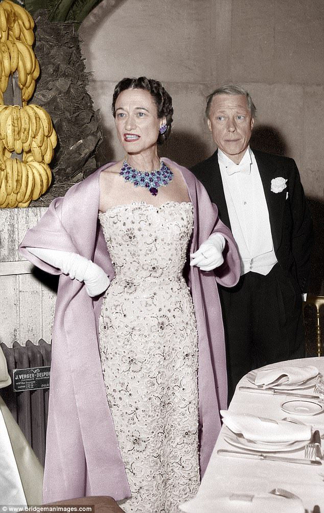 an old photo of a man and woman standing next to each other at a dinner table