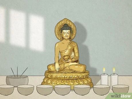 a buddha statue sitting on top of a table next to bowls and candles in front of it