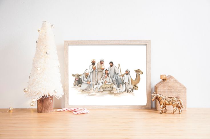 a christmas tree and some figurines in front of a white wall with a painting on it