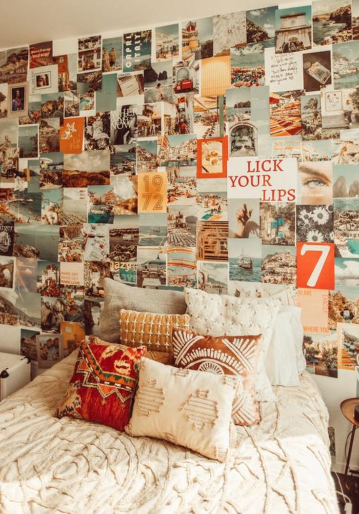 a bed with lots of pillows and pictures on the wall